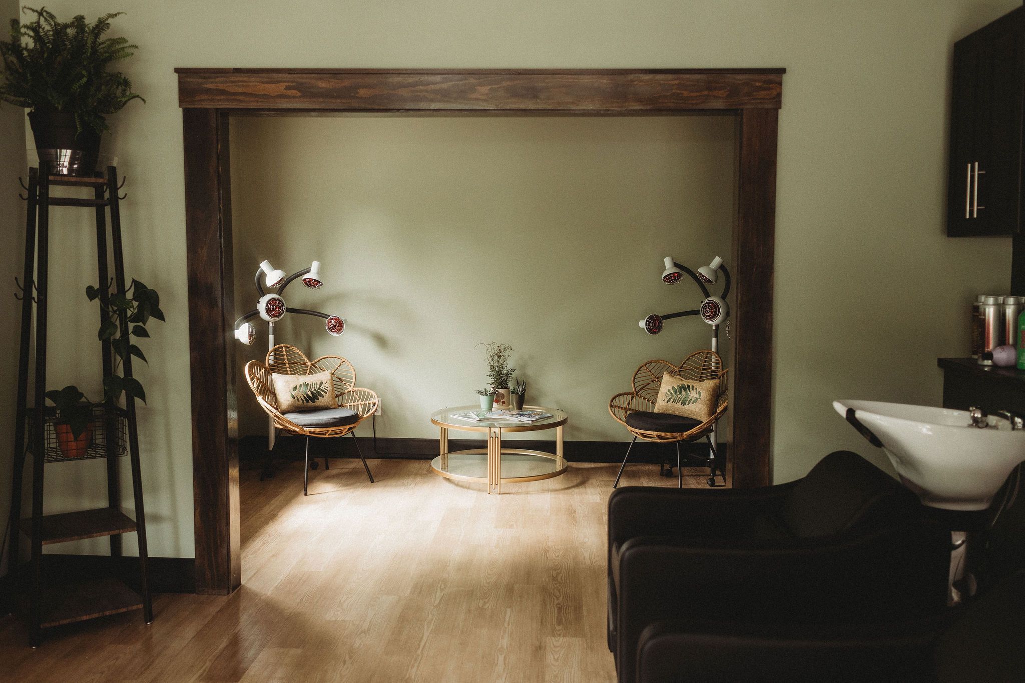 Waiting nook with rattan chairs and processing lamps under a wood archway